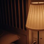 Stijlvolle hanglamp naast een bed in een sfeervolle slaapkamer, perfect voor verlichting en decoratie.